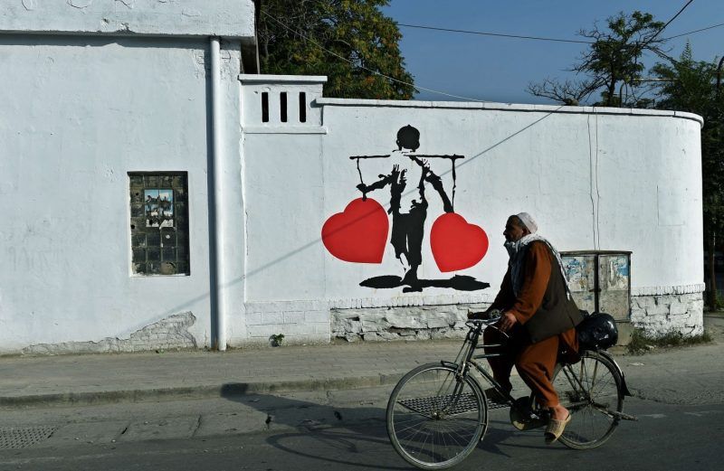 An Afghan rides past a painting aimed to combat corruption in Kabul. (Wakil Kohsar/AFP/Getty Images)