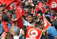 Tunisians wave their national flag and chant slogans during a march against extremism outside Tunis' Bardo Museum on March 29, 2015 following the massacre of foreign tourists at the country's national museum. (Fethi Belaid/AFP/Getty Images)