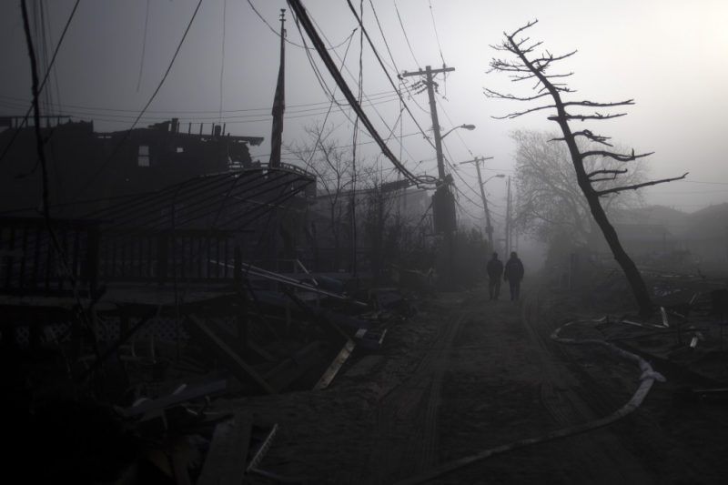 Residents walk through the Breezy Point neighborhood which was left devastated by Hurricane Sandy in the New York borough of Queens, November 12, 2012. REUTERS/Adrees Latif