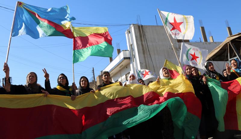 Kurdish women hold flags and banners of the PYD during a demonstration against the exclusion of Syrian Kurds from the Geneva talks on 4 February 2016. Photo by Getty Images.