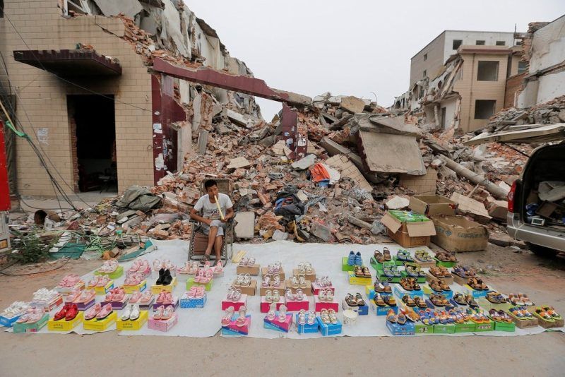A vendor waits for customers at a market in an urban village under demolition in Zhengzhou, Henan province, in May. China Stringer Network/Reuters