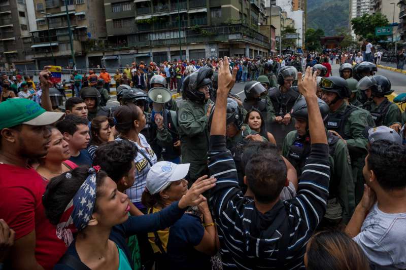 Un grupo de personas manifiestan contra miembros de la Guardia Nacional Bolivariana en Caracas en protesta por la carestía. MIGUEL GUTIERREZ (EFE)