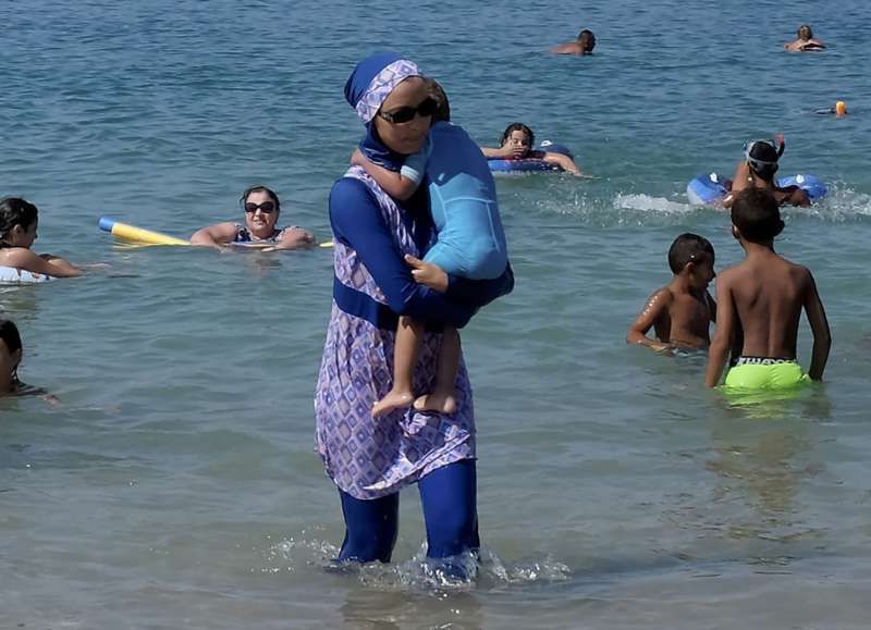 A woman in a burkini walks on a beach in Marseille, France, on Aug. 27, the day after the country's highest administrative court suspended a ban on full-body burkini swimsuits. (Stringer/Reuters)