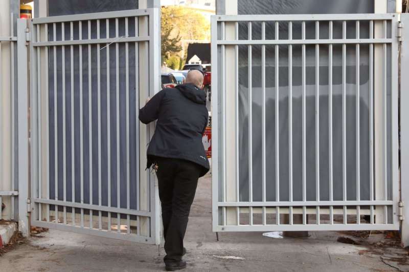 A bodyguard closing the gates to the official residence of Prime Minister Benjamin Netanyahu of Israel on Jan. 2, blocking the view as the press awaited the arrival of police investigators looking into gifts Mr. Netanyahu received. Credit Gali Tibbon/Agence France-Presse — Getty Images