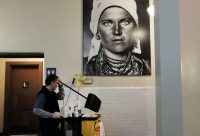 A custodian under a portrait of an immigrant, Ellis Island, New York, January 31, 2017