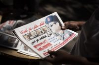 An Egyptian man holds a newspaper near Mesaha Square in Cairo on July 4, 2013, after the military ousted Islamist President Mohamed Morsi. (Manu Brabo/AP)