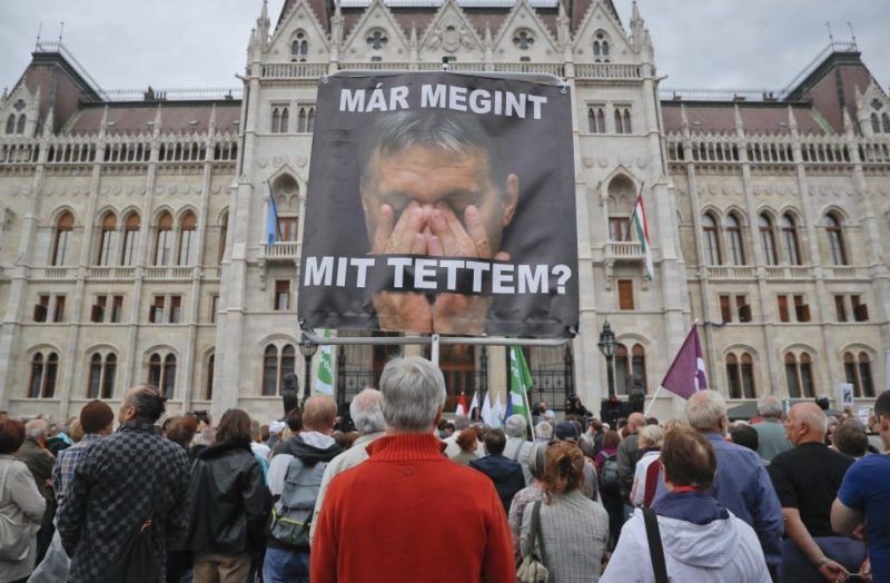 A man holds a poster of Hungarian Premier Viktor Orban that reads “What have I done again” during a protest by opposition parties against Orban’s policies on migrants. (AP)