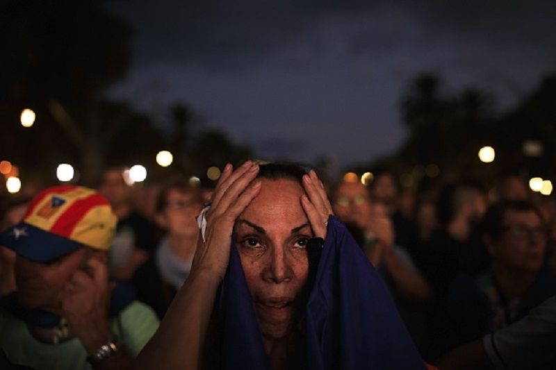 BARCELONA, SPAIN - OCTOBER 10 : A supporter of Catalonia independence reacts as she follows the Catalonian Parliament plenary session on a giant screen at Passeig de Lluis Companys on October 10, 2017 in Barcelona, Spain. Catalan President Carles Puigdemont said that while he supports an independence declaration, one should be held off for a few weeks to allow for dialogue and mediation. (Photo by Gonzalo Arroyo Moreno/Anadolu Agency/Getty Images)