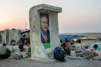 Pesh merga troops near an image of Jalal Talabani, a Kurd and former Iraqi president, in 2014. Credit Andrea Bruce for The New York Times