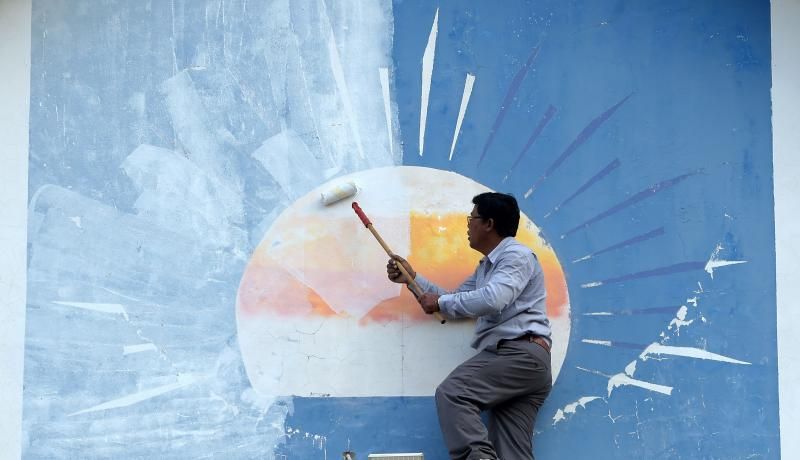 A man paints over the logo of the Cambodia National Rescue Party at its headquarters in Phnom Penh. Photo: Getty Images.