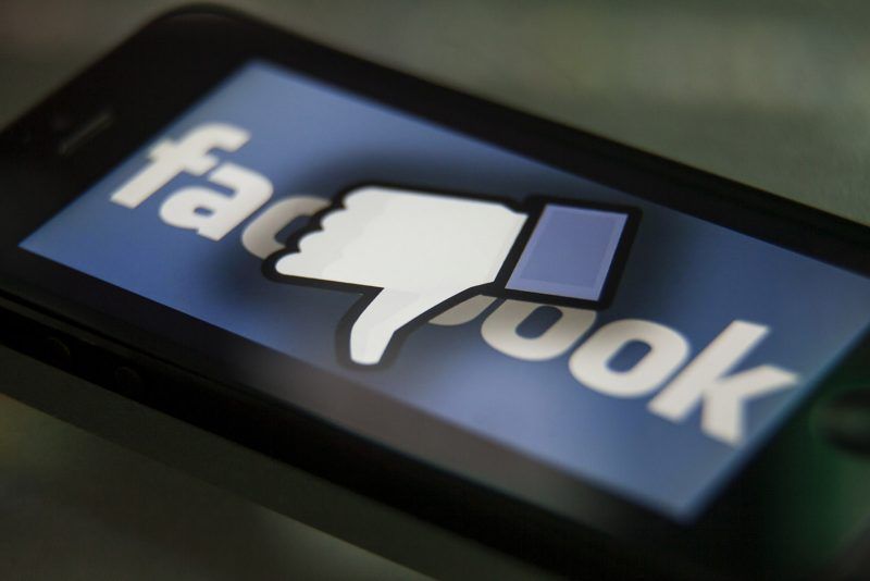 Facebook thumbs-down hand on a iPhone. Facebook is a social media company owned by Mark Zuckerberg. (Photo by Ted Soqui/Corbis via Getty Images)
