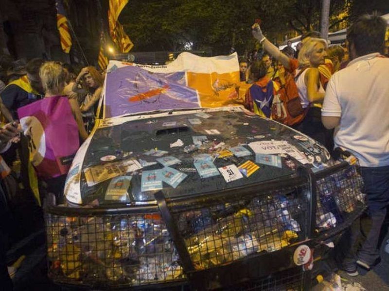 Un coche de la Guardia Civil vandalizado durante el asedio a la Consejería de Economía. Quique García - EFE - Barcelona