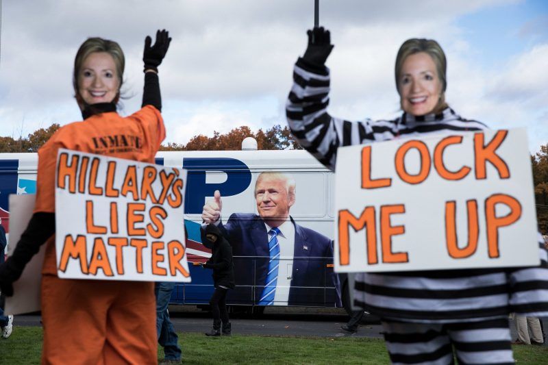People in prison garb wearing Hillary Clinton masks outside a Trump campaign event in 2016. Credit Damon Winter/The New York Times