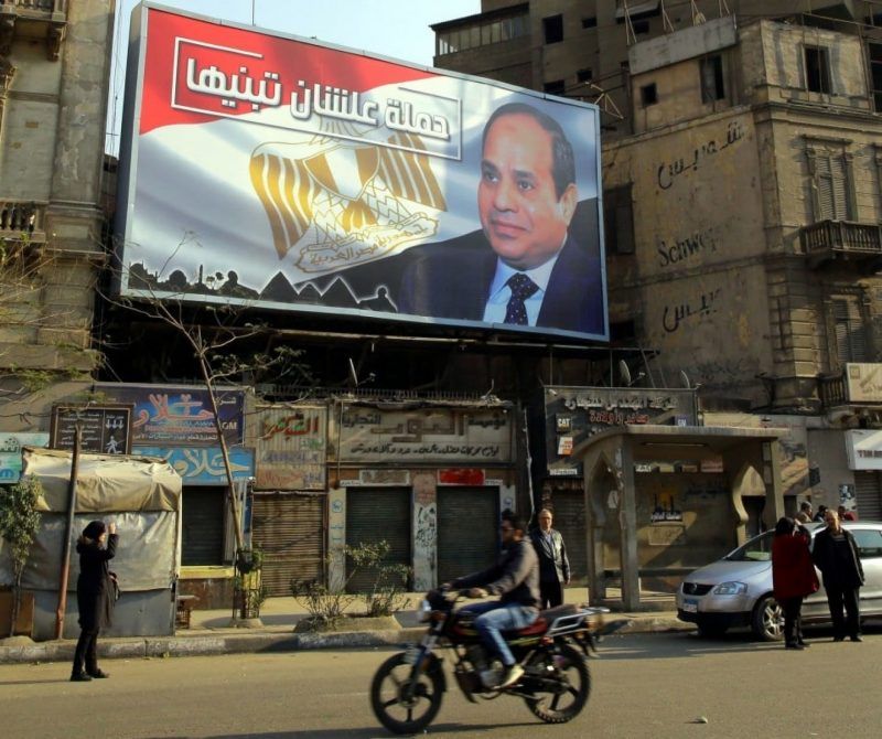 Egyptians walk underneath an election campaign poster erected by supporters of Egyptian President Abdel Fatah al-Sissi, in Cairo on Jan. 28. (Khaled Elfiqi/European Pressphoto Agency-EFE/REX/Shutterstock)
