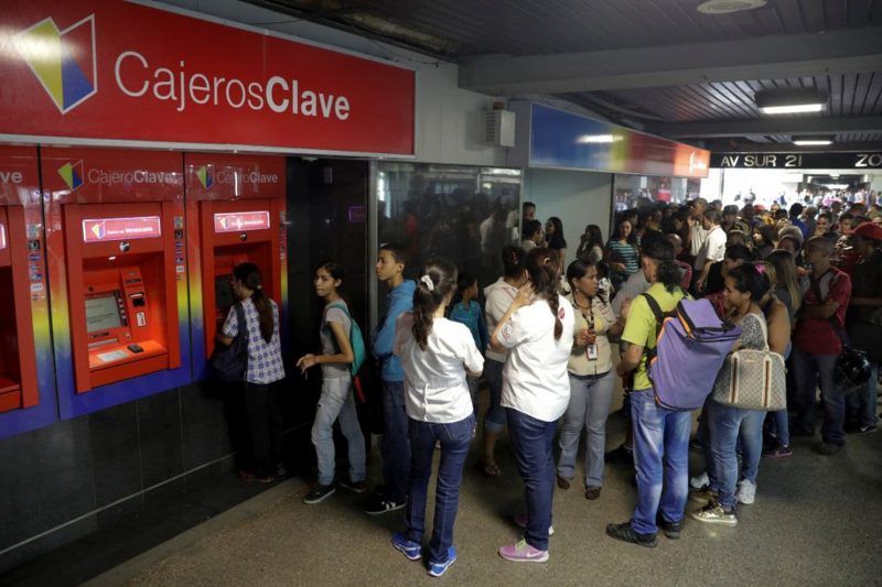 Customers wait in line at an ATM outside a Banco de Venezuela branch in Caracas, Venezuela, on March 23. (Marco Bello/Reuters)