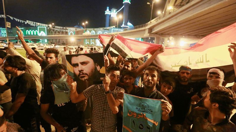 Iraqi supporters of Sairun list celebrate with Iraqi flags and a picture of Shi'ite cleric Moqtada al-Sadr after results of Iraq's parliamentary election were announced, in Najaf, Iraq 15 May, 2018. REUTERS/Alaa al-Marjani