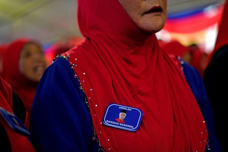 A supporter wears a lapel pin bearing a portrait of Prime Minister Najib Razak of the ruling coalition party Barisan Nasional during a campaign event in Kuala Lumpur, Malaysia, this month. Credit Manan Vatsyayana/Agence France-Presse — Getty Images