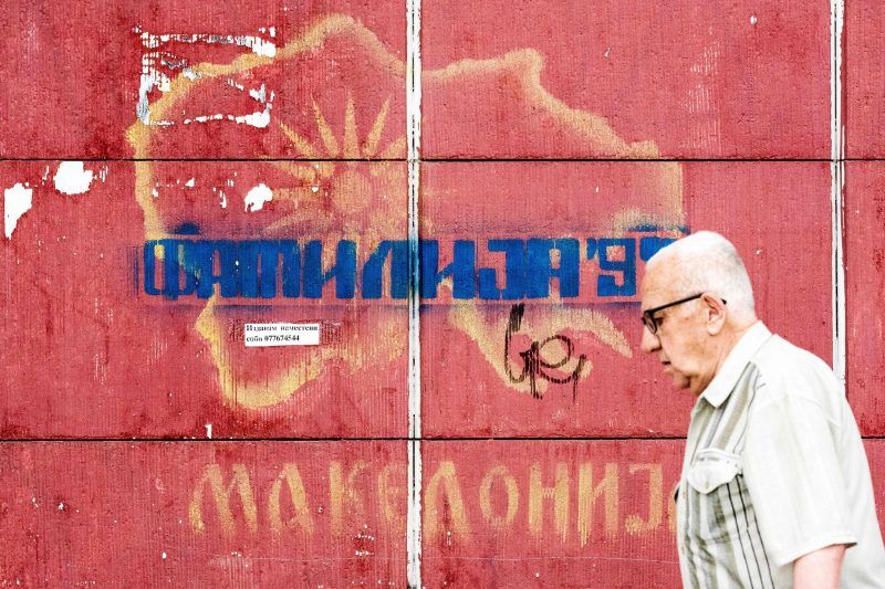 A man passes in front of a graffiti with an old map of Macedoni in Skopje on Wednesday.Credit Robert Atanasovski/Agence France-Presse — Getty Image