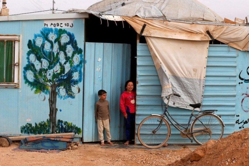 Syrian refugee children stand in front of their home at Al Zaatari refugee camp, in the Jordanian city of Mafraq near the border with Syria, in February. (Muhammad Hamed/Reuters)