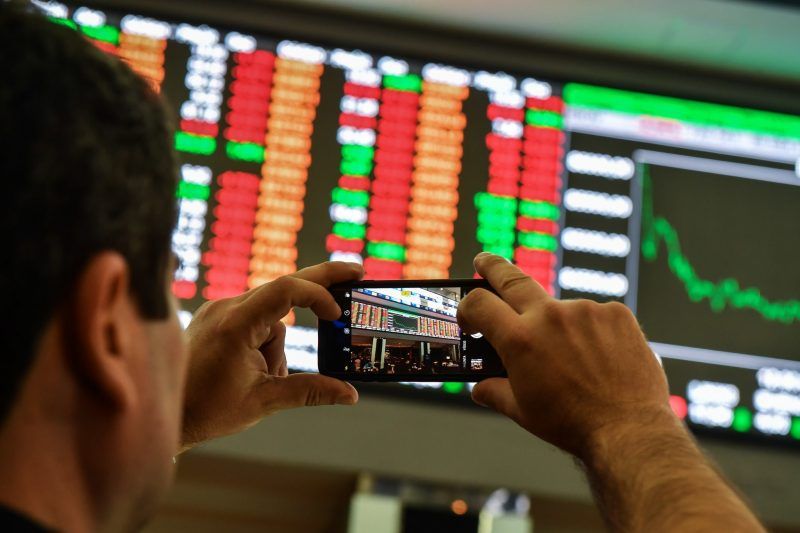 A visitor took pictures of an electronic board at the São Paulo Stock Exchange in São Paulo, Brazil, on Wednesday. Credit Nelson Almeida/Agence France-Presse — Getty Images
