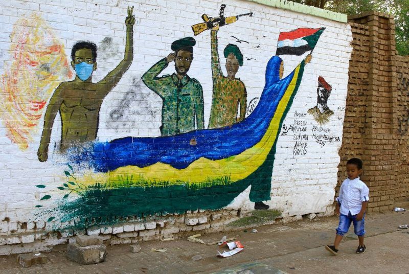 A Sudanese child walks past a mural depicting protesters and soldiers on a street in Khartoum, Sudan, on Tuesday. Sudanese protesters continued their sit-in and gatherings near the army headquarters, pressing for a civilian council instead of the current military one. (Str/EPA-EFE/REX/Shutterstock)