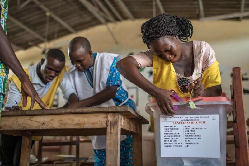 A polling official cuts the seal of a ballot box during the elections for a new parliament in Cotonou, Benin, on April 28. (Yanick Folly/AFP/Getty Images)