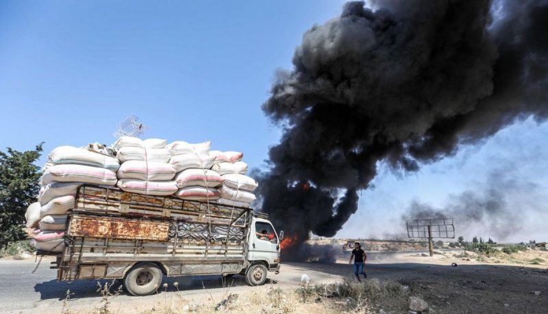 Smoke rises from a blaze at a vehicle gathering point for civilians fleeing from the south of Idlib province after a government bombardment in the village of Maar Shurin in northwestern Syria on Aug. 25. (Omar Haj Kadour/AFP/Getty Images (Omar Haj Kadour/AFP/Getty Images)
