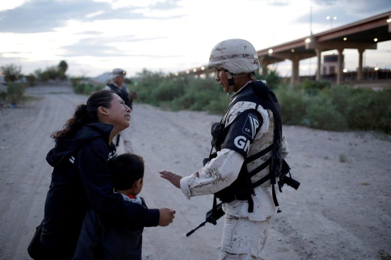 Una mujer guatemalteca le pide a un miembro de la Guardia Nacional de México que la deje cruzar a Estados Unidos en Ciudad Juárez. Credit José Luis González/Reuters