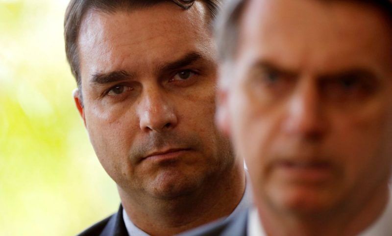 Flávio Bolsonaro, pictured behind his father, President Jair Bolsonaro, employed the wife and the mother of the alleged leader of Rio de Janeiro’s top paramilitary gang for years. Photograph: Adriano Machado/Reuters