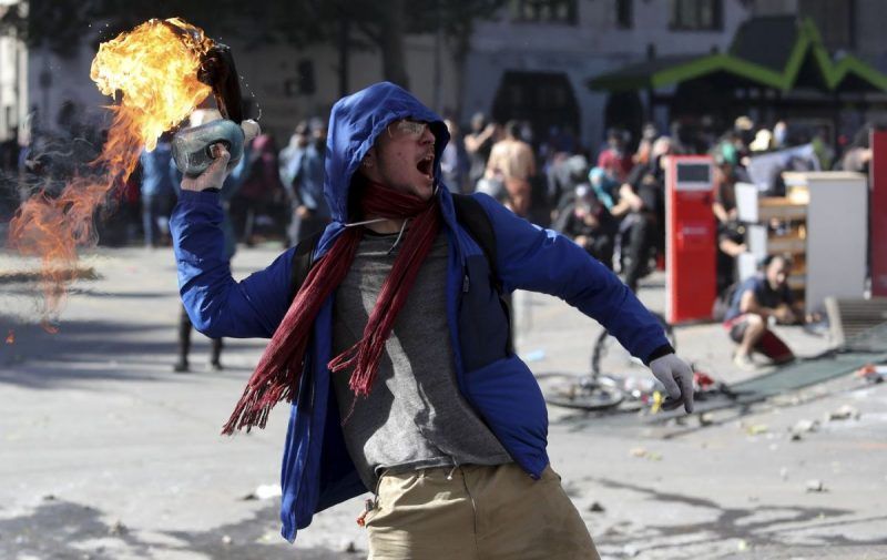 Un manifestante lanza una bomba molotov hacia la Policía en Santiago, la capital de Chile, en una protesta. Las autoridades han remprimido las movilizaciones que han dejado ya 11 muertos. (Miguel Arenas)