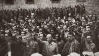 Prisioneros de San Pedro de Cardeña (Burgos) haciendo el saludo fascista. Fotografía de los fondos de la Biblioteca Nacional de España.