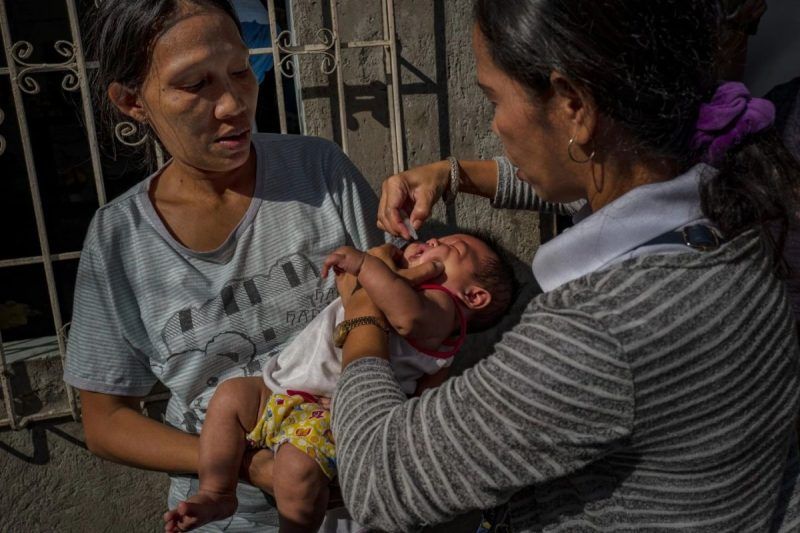 A community health worker administers an oral polio vaccine to a child, during a mass vaccination campaign in Manilla, Philippines, on Oct. 13. (Ezra Acayan/Getty Images)
