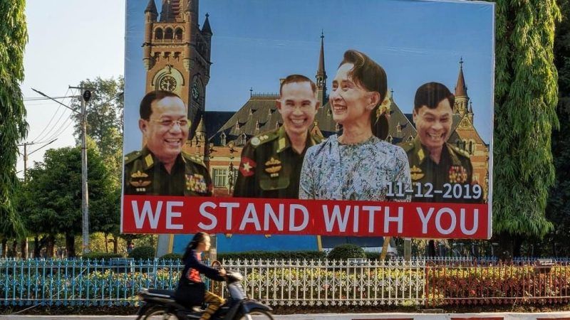 A billboard depicting Myanmar State Counsellor Aung San Su Kyi with the three military ministers in front of a background showing the building of the International Court of Justice in The Hague is displayed along a main road in Hpa-an, Karen State. AFP
