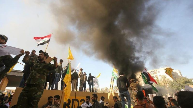 Members of Iraq's pro-Iranian al-Hashd al-Shaabi group and protesters set ablaze a sentry box outside the U.S. Embassy in Baghdad on 31 December 2019. AHmad al-Rubaye/Agence France Presse