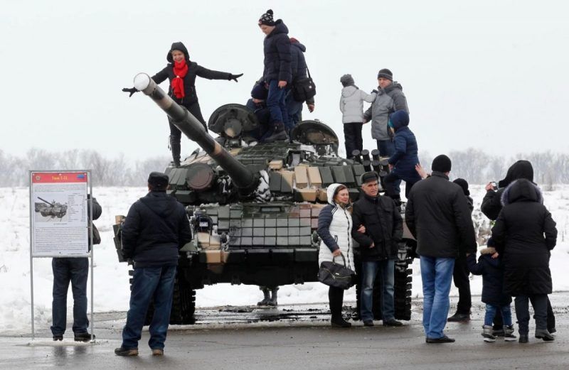 People pose on T-72 battle tank during a Defender of the Fatherland Day celebration Feb. 23 at a former airport in Luhansk, Ukraine. (Dave Mustaine/EPA-EFE/Shutterstock)