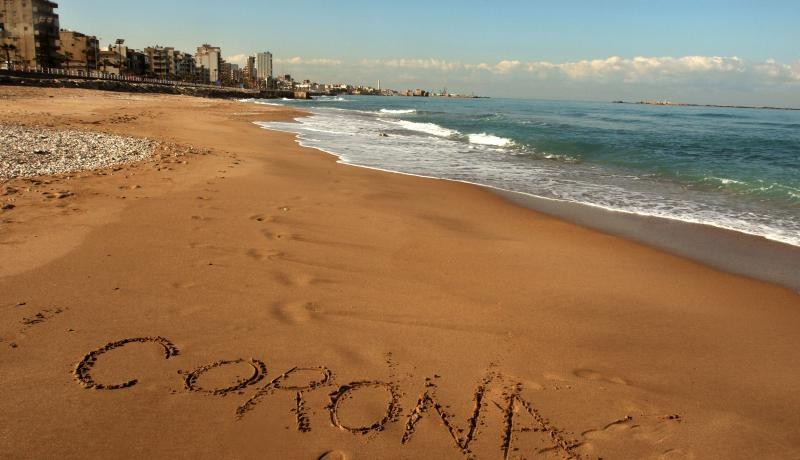 The word Corona written in the sand on the beach in Lebanon's southern city of Saida. amid the spread of coronavirus in the country. Photo by MAHMOUD ZAYYAT/AFP via Getty Images. 