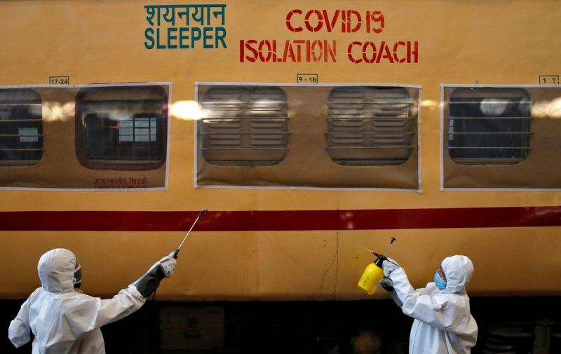 Workers disinfect a passenger train outside Kolkata, India, after it was converted into an isolation facility to deal with the coronavirus. (Rupak De Chowdhuri/Reuters)