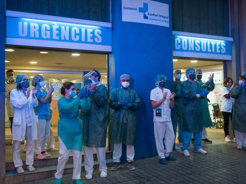 Medical workers in Barcelona returning applause to residents who have applauded them. Health care professionals have denounced the failure of their authorities to protect them adequately.Credit Samuel Aranda for The New York Times