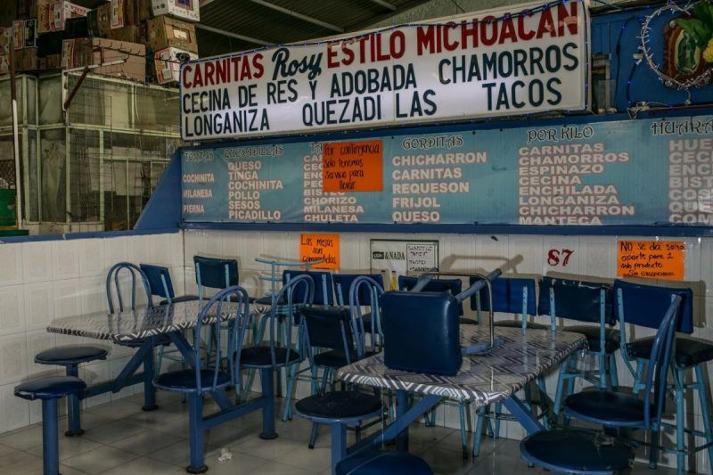 An empty taco stall in Mercado la Dalia in Mexico City. Signs advertise food to go. (Meghan Dhaliwal/FTWP)
