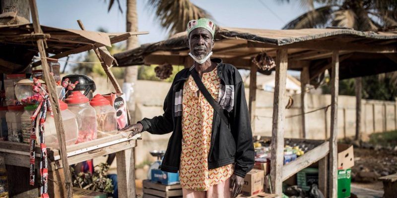 El senegalés Thierno Mamoudou, dueño de una tienda de la esquina local, posa para una foto en Dakar el 22 de abril de 2020 durante la pandemia del coronavirus COVID-19. El encierro nocturno implementado por el gobierno senegalés desde las ocho de la noche hasta las seis de la mañana ha sido un duro golpe para su negocio. John Wessels/AFP via Getty Images.