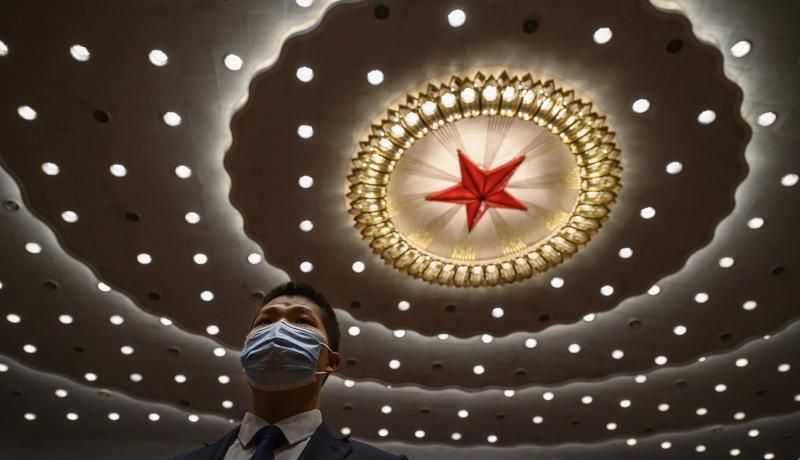 A Chinese security officer wears a protective mask at the end of the closing session of the National People's Congress at the Great Hall of the People. Photo by Kevin Frayer/Getty Images. 