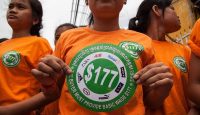 Garment workers hold stickers bearing US$177 during a demonstration to demand an increase of their minimum salary in Phnom Penh, Cambodia. Photo by Omar Havana/Getty Images.
