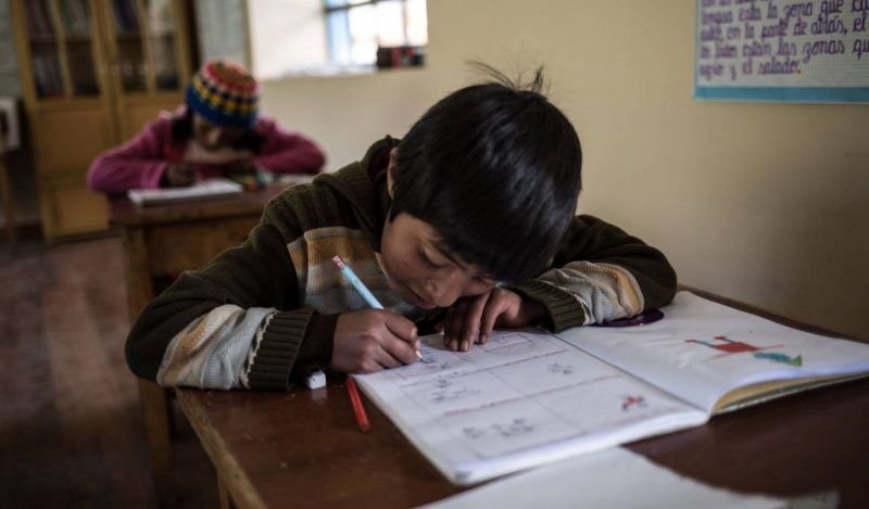 Un niño hace los deberes durante una clase en el colegio de Huaycho, una localidad campesina de Puno, en Perú. Lys Arango