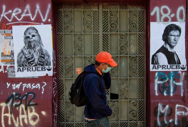A man walks by posters of “Star Wars” characters Chewbacca and Han Solo reading “I Approve” in reference to the Oct. 25 referendum to change Chile's military dictatorship-era constitution, in Santiago on Wednesday. (Martin Bernetti/AFP/Getty Images)