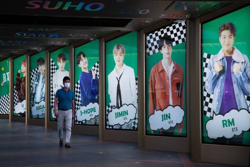 A man walks past an advertisement for K-pop boy band BTS in Seoul, South Korea, on Sept. 18. (SeongJoon Cho/Bloomberg)