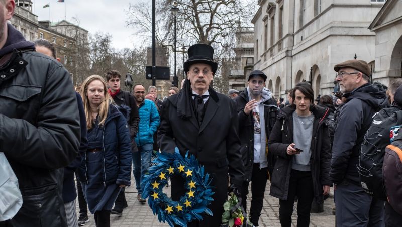 A man in funeral attire carried a European Union wreath on Jan. 31, the day Britain formally withdrew from the bloc. Credit Andrew Testa for The New York Times