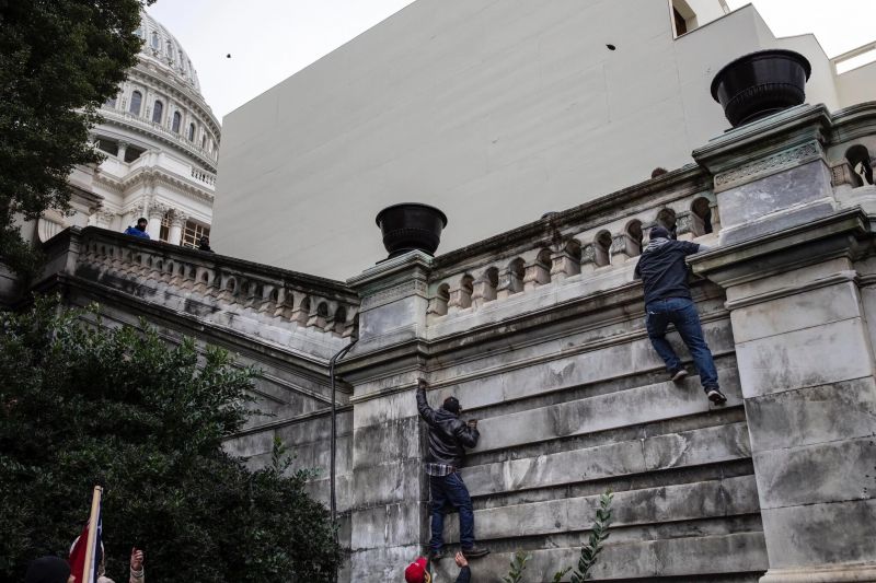 Los extremistas pro-Trump intentan escalar las paredes del edificio del Capitolio en Washington para pasar las barreras y entrar, 2:09 p. m. Ashley Gilbertson/VII para The New York Times