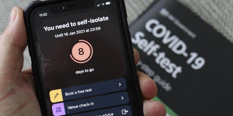 A person who has returned a positive test holds a mobile phone showing they have been told to self-isolate for a further eight days by the NHS COVID-19 app, on 9 January 2021 in Caerphilly, Wales. Photo credit: Copyright © Huw Fairclough/Contributor/Getty 