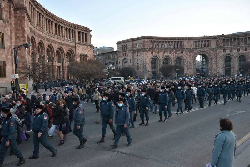 Armenians, flanked by police officers, take part in a protest to demand the resignation of Prime Minister Nikol Pashinyan in Yerevan, Armenia, on March 6. (Karen Minasyan/AFP/Getty Images)