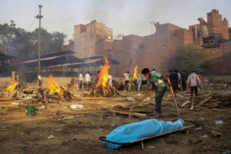 A man prepares a funeral pyre for a coronavirus victim at a cremation ground in New Delhi on Thursday. (Danish Siddiqui/Reuters) 